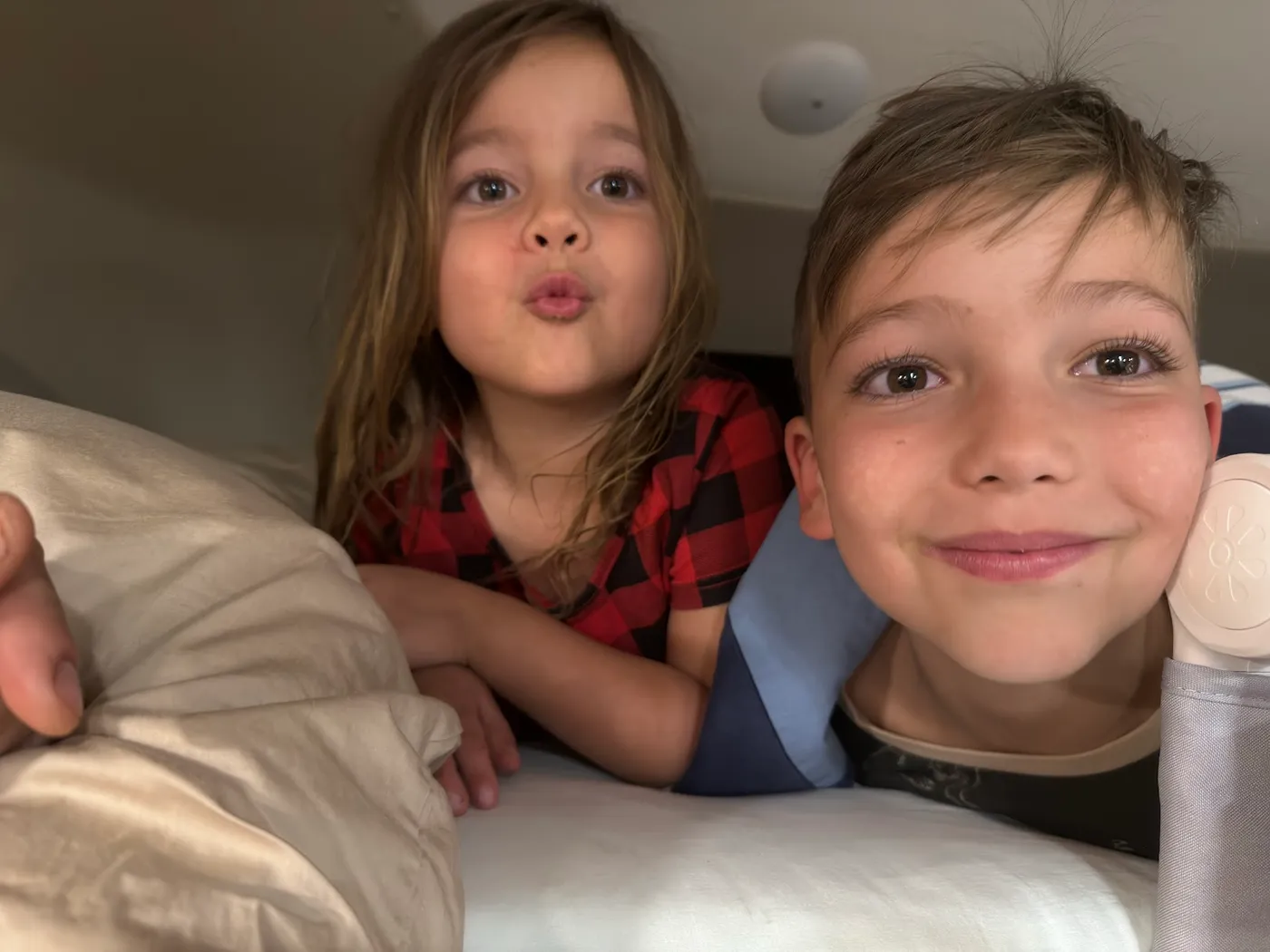 The kids grinning from the bunk inside the motorhome