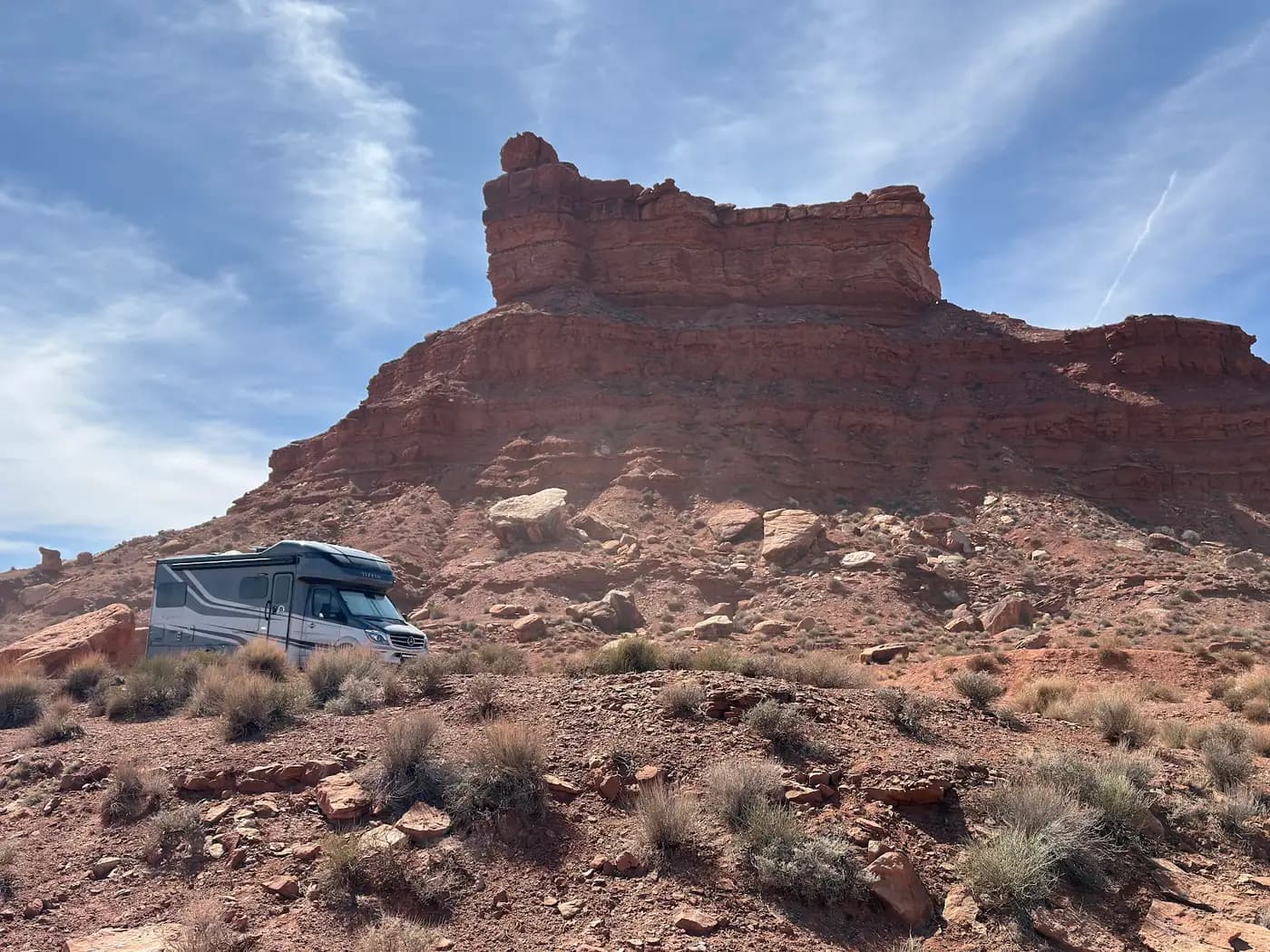 Our Class C motorhome parked beneath a sandstone butte in Valley of the Gods, Utah